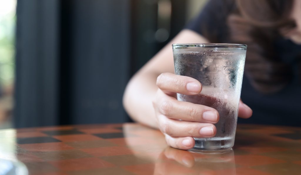 woman holding a glass of cold water 
