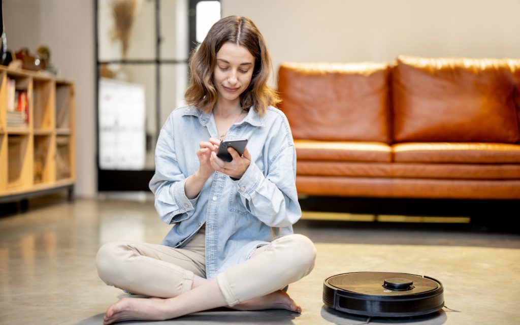 woman with phone programming her roomba