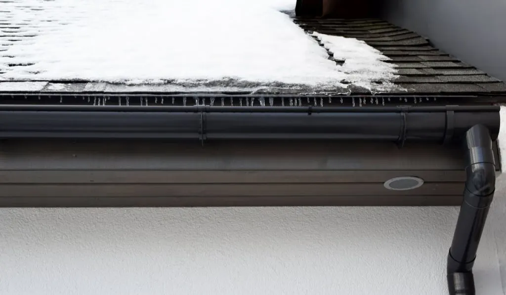 ice on roof and gray gutter 