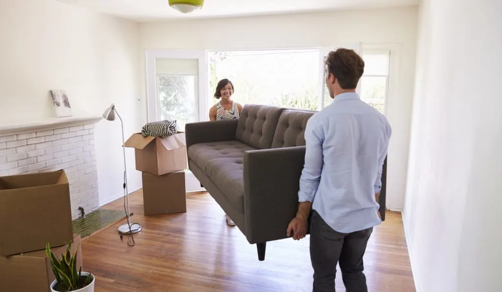 man and woman rearranging furniture 