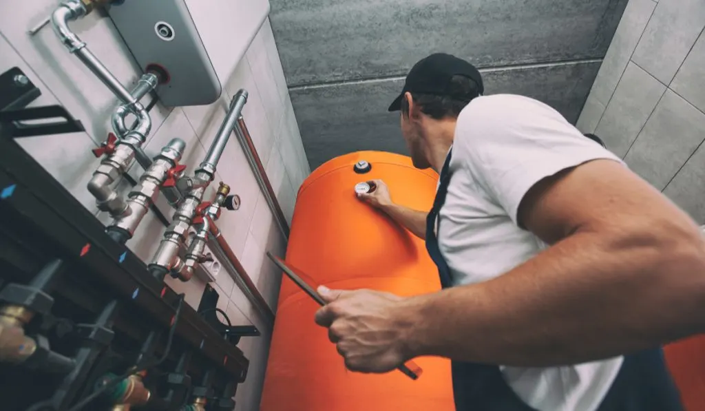 man checking heat pump water heater