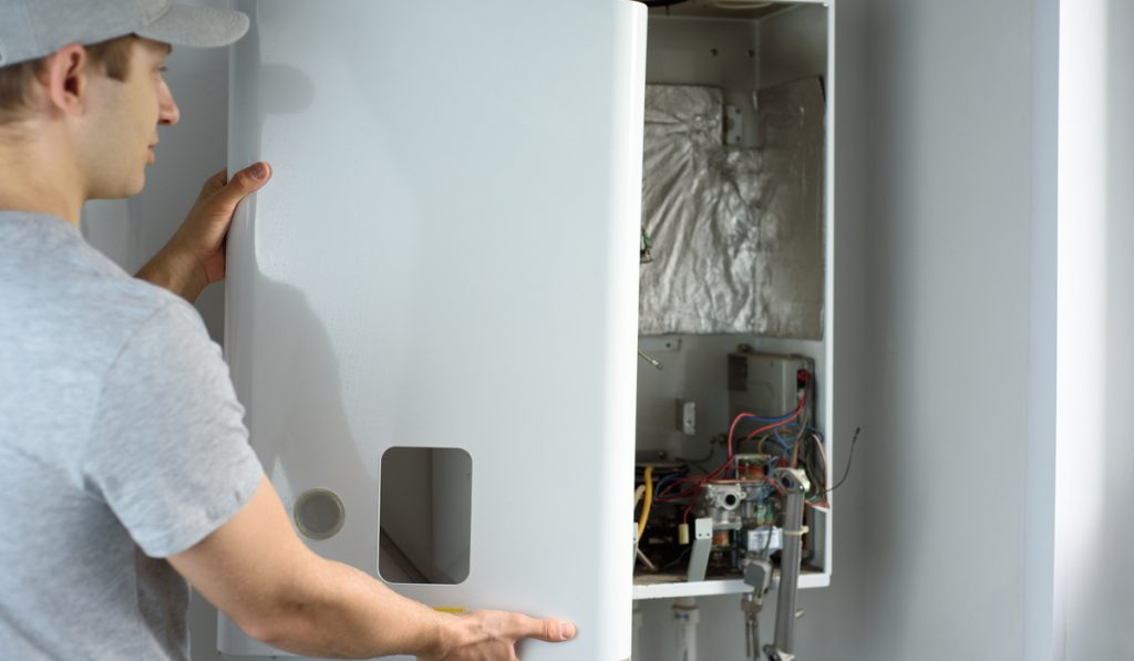 man checking inside the condensing water heater