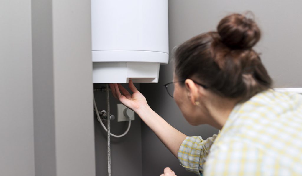 woman checking their water heater 