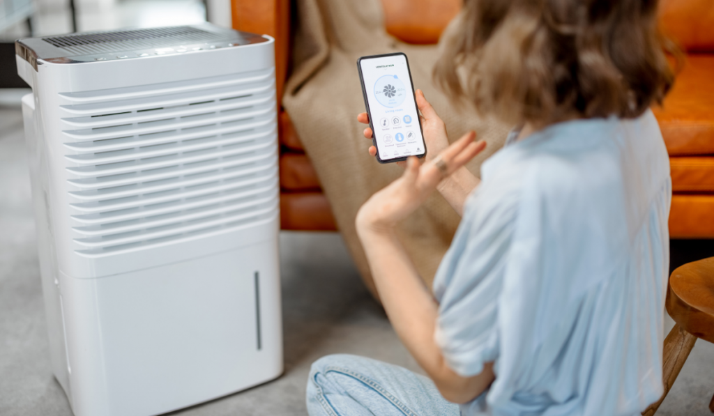 Woman sitting near air purifier and moisturize