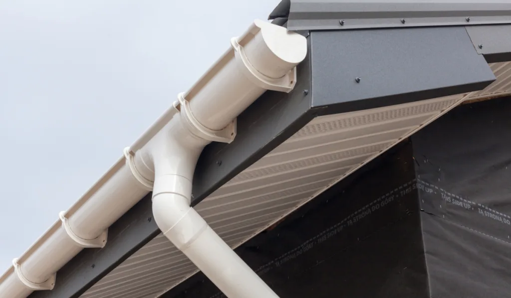 gray metal tile roof with white rain gutter