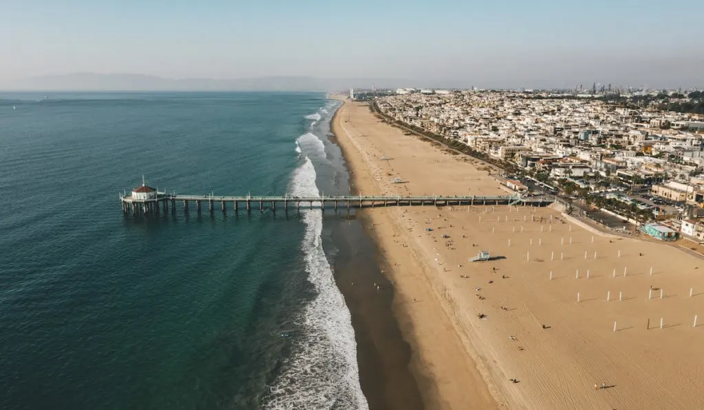 Aerial View over Manhattan Beach in California with Green Blue Water and Blue Sky