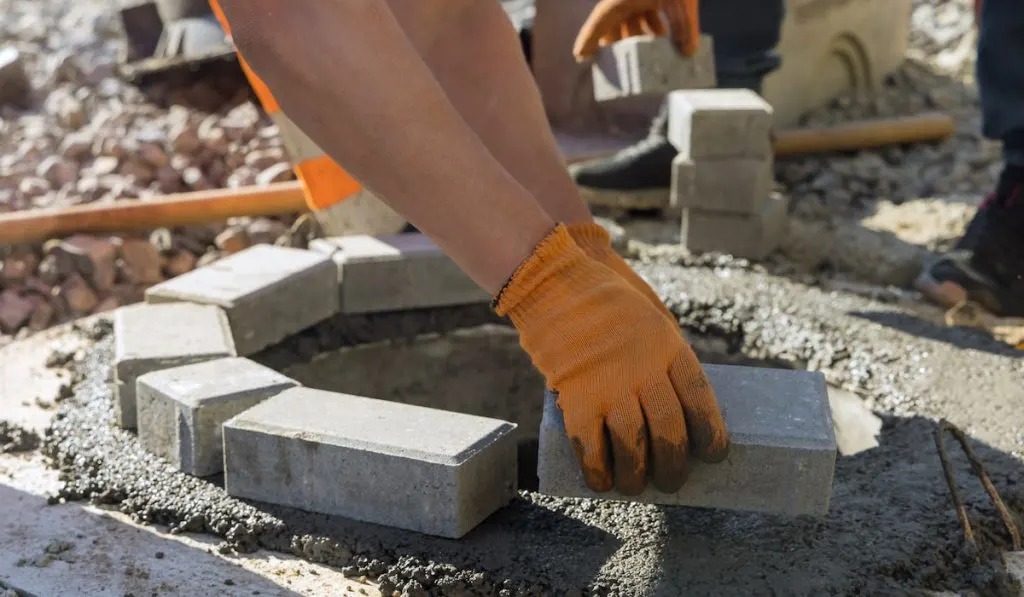 Utility worker installing manhole sewage reconstruction a pit for a septic tank
