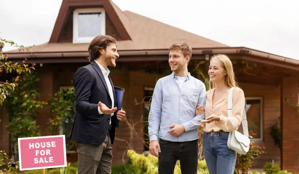 couple talking to real estate agent about purchasing a new house