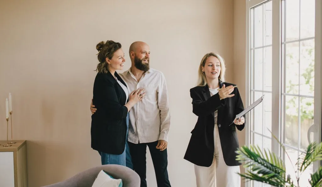 Real estate agent demonstrates a new apartment to a happy couple. Buying a property.
