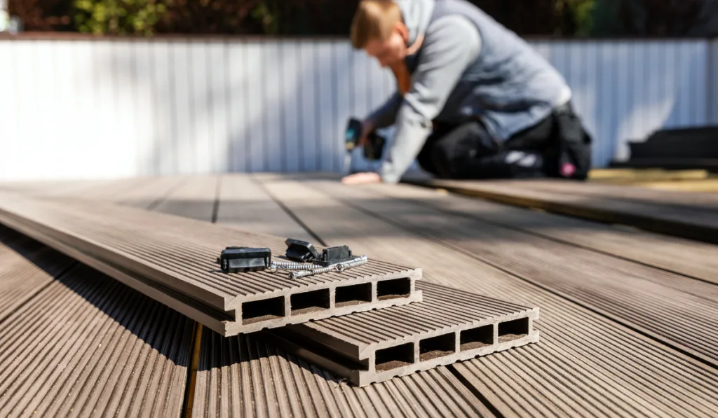 worker installing wood plastic composite decking boards