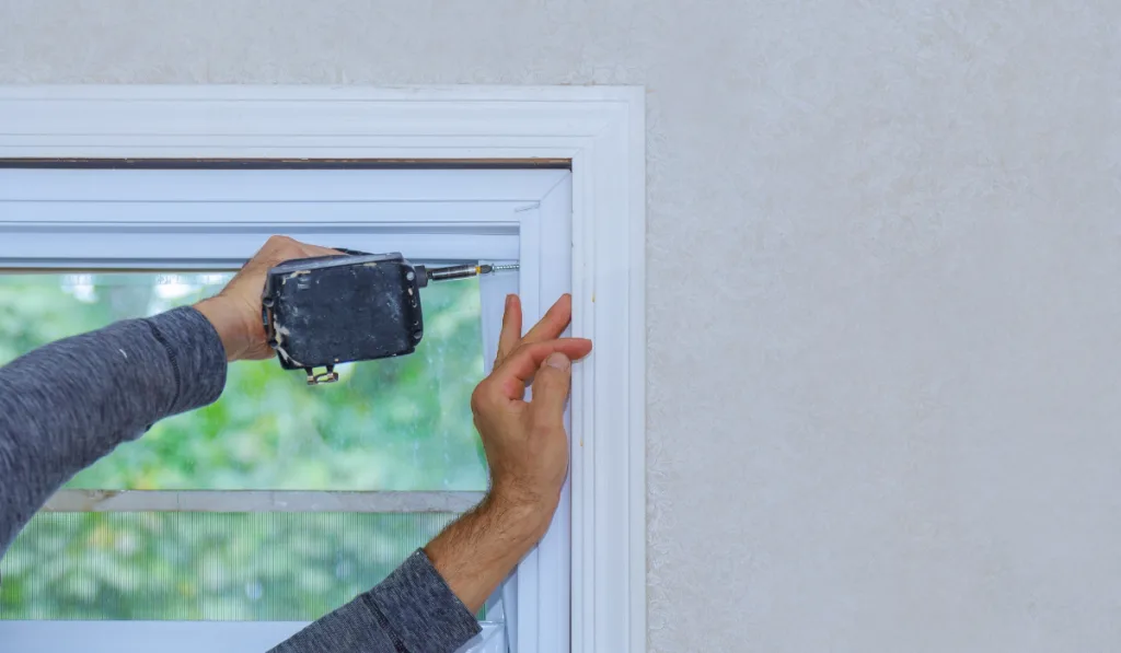 Construction worker installing window in a new house

