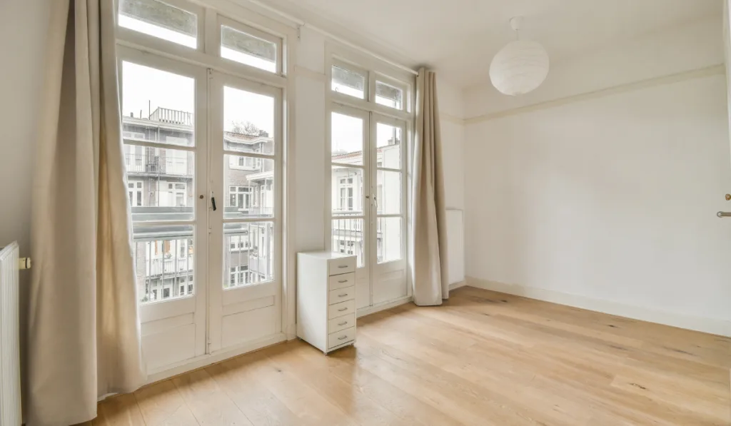 Modern room with beautiful window, wooden floor and white walls

