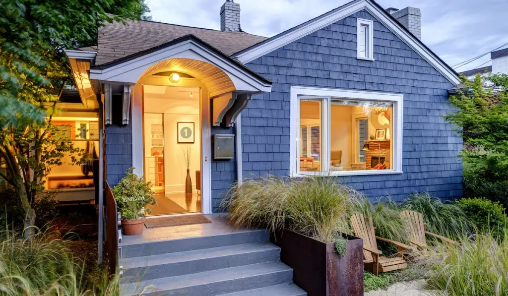 Illuminated front stoop and of blue house