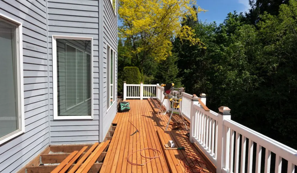 Installation of outdoor wooden deck with new red cedar wood floor boards