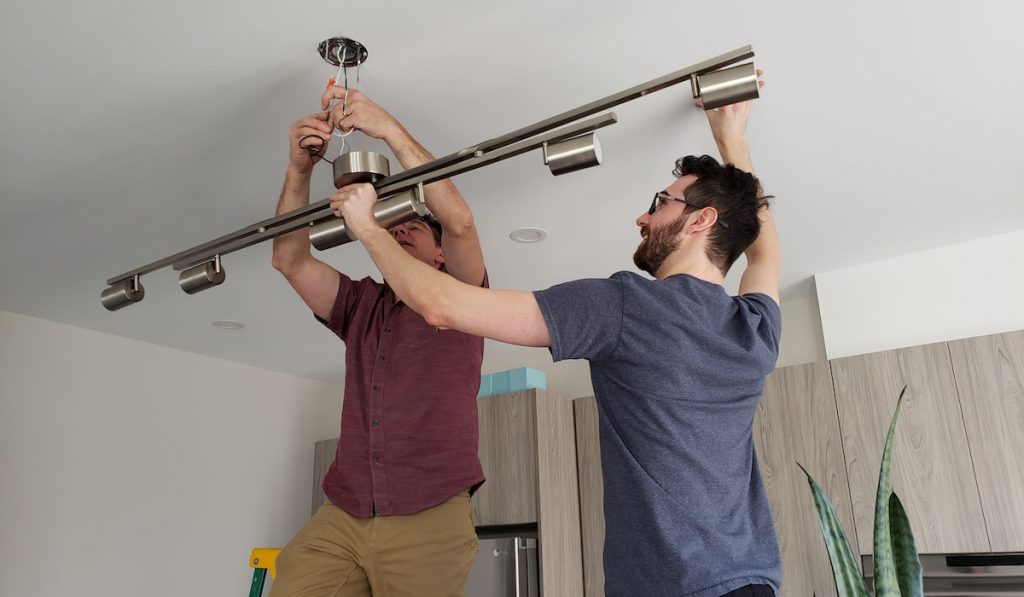 Men doing home renovation, changing light fixtures