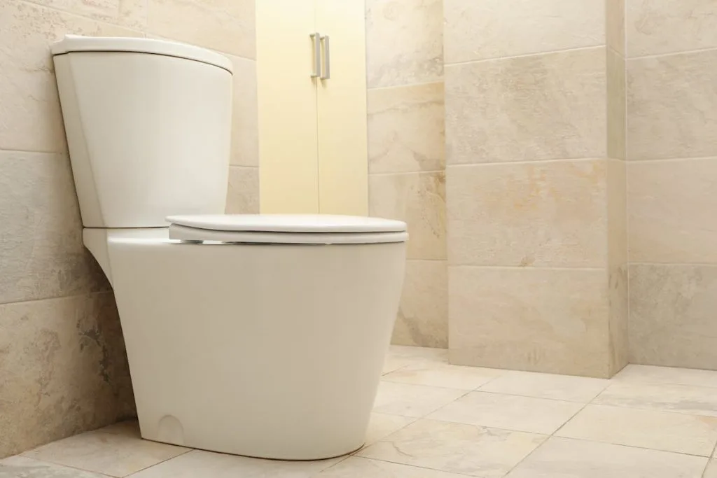 Toilet bowl in modern bathroom in light beige color
