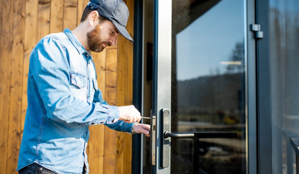 man installing new glass door of the modern house
