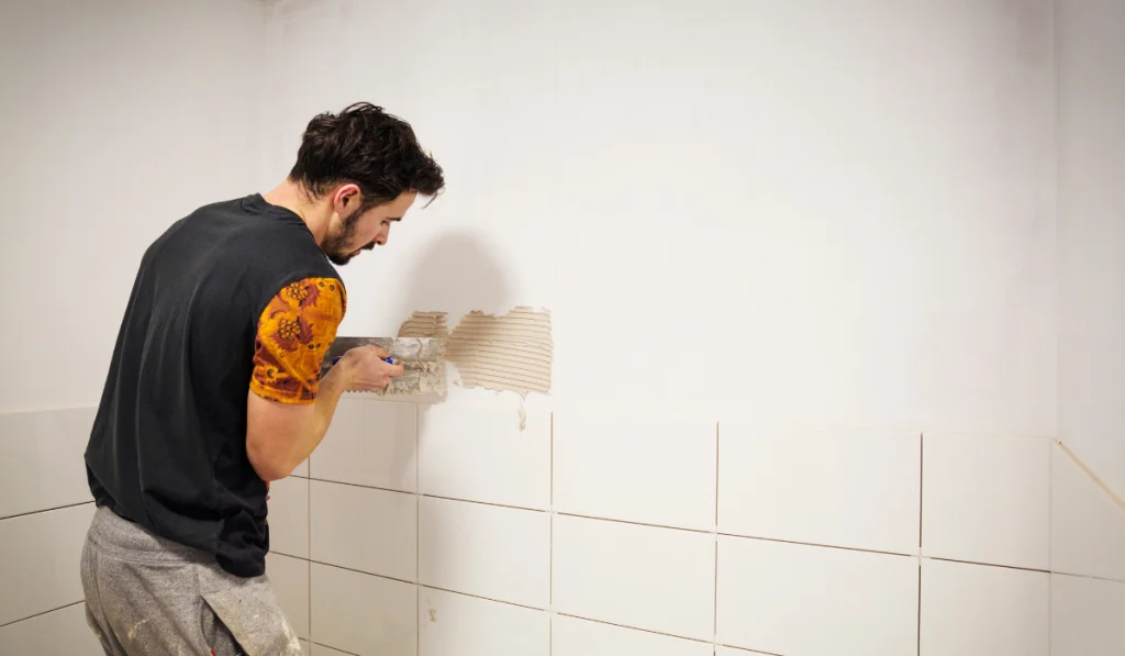 tiler placing white ceramic tiles