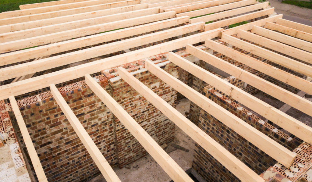 Close up of a brick house with wooden ceiling frame under construction