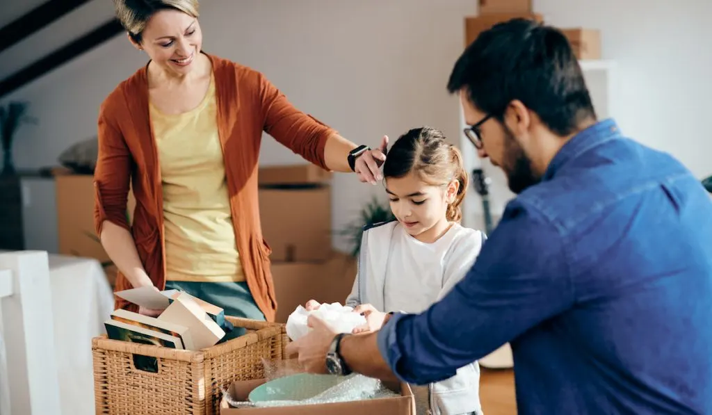 Happy family unpacking their belongings at their new home.
