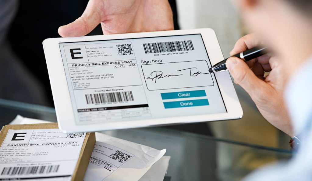 Man signing delivery receipt on digital tablet
