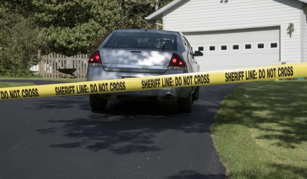 Police vehicle and crime scene tape protecting the house scene