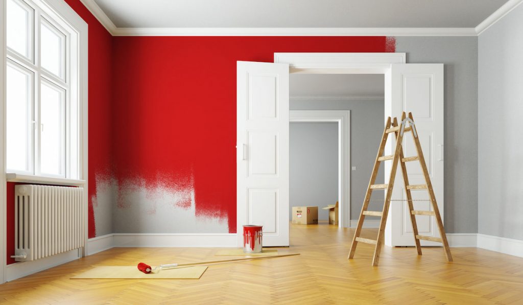 Red paint wall during renovation in a large empty room 