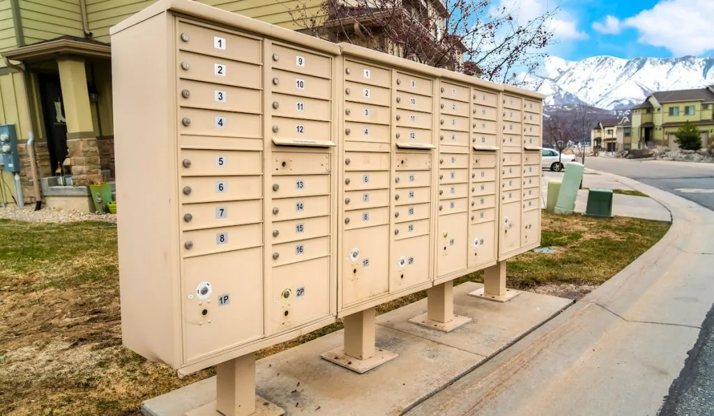 Residential mailboxes with numbered compartments on the side of a road