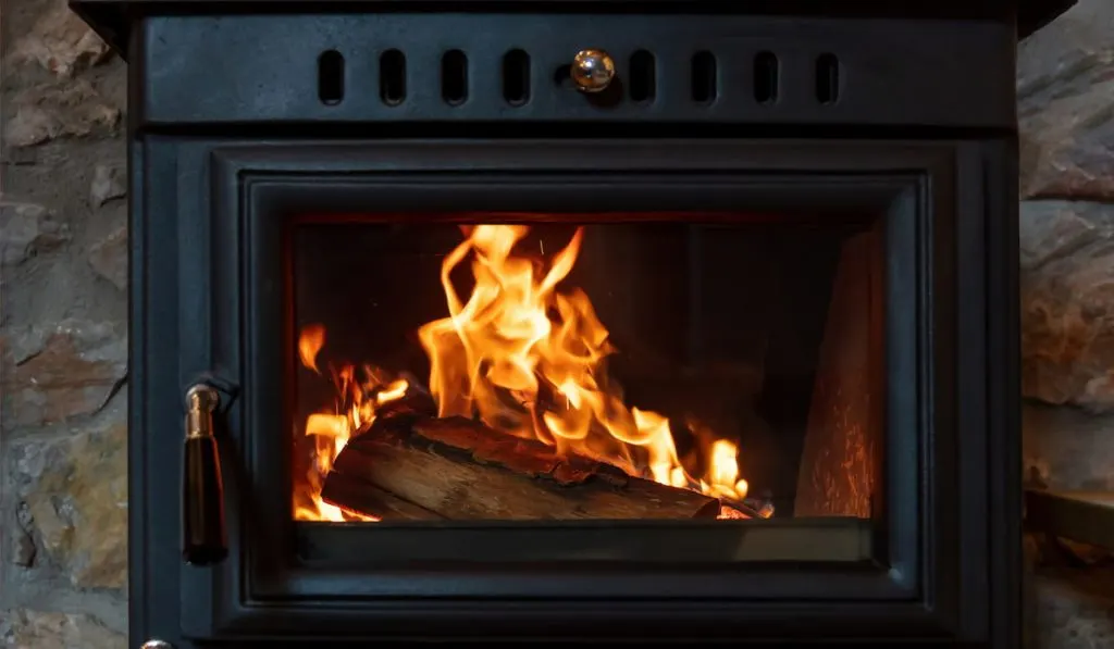 Burning fire in a wood stove fireplace radiates heat