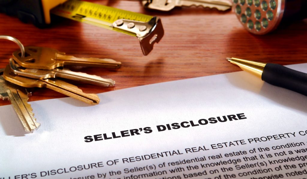 Homeowner seller property disclosure condition statement with house keys and inspection flashlight on a desk