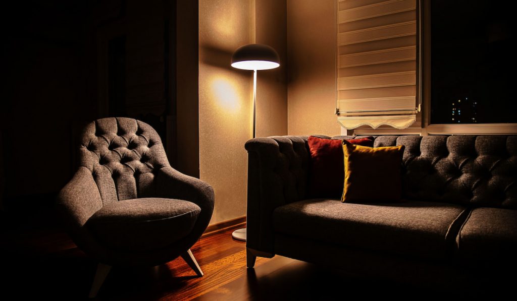 Night view of a living room with lights on floor lamp