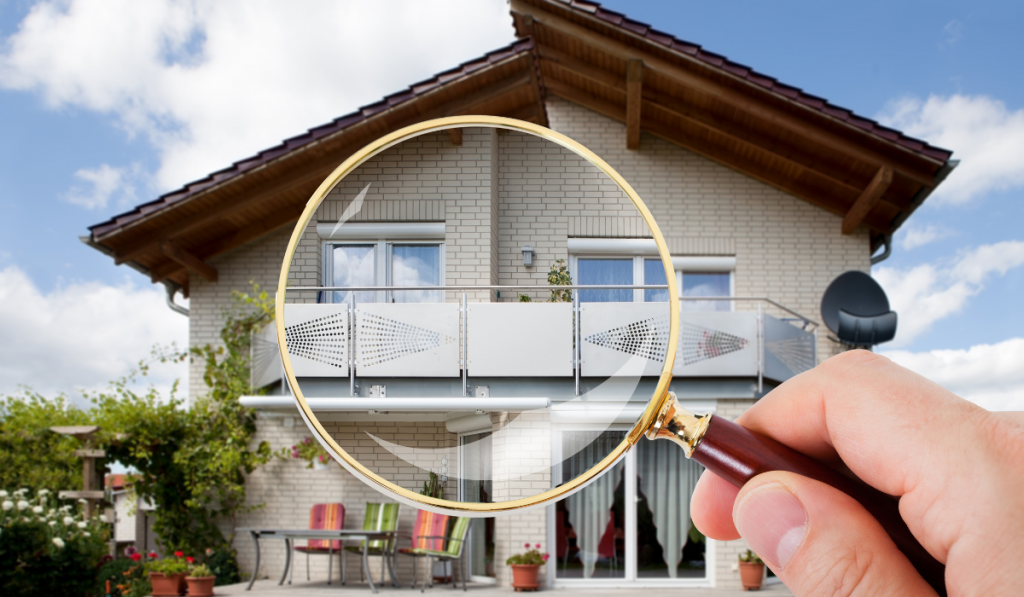 Person Hand With Magnifying Glass Over Luxury House
