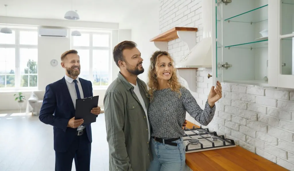 Realtor with buyer doing pre-purchase inspection checking the new house 