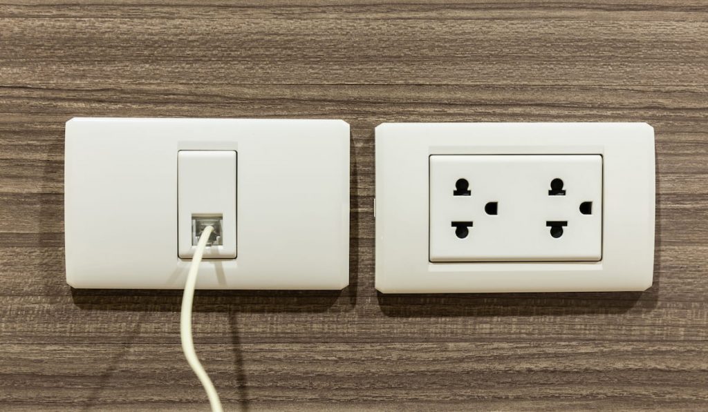 Wall socket and telephone wall socket in room for plug or phone jack.