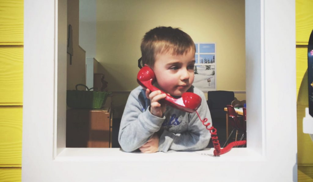 Young boy talking on an old landline telephone